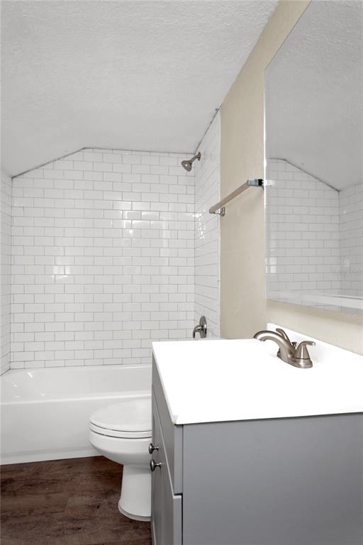 A bathroom features a white subway tile shower surround, a gray vanity, and wood-look flooring — 847 JASMINE AVENUE, HOLLY HILL, FL