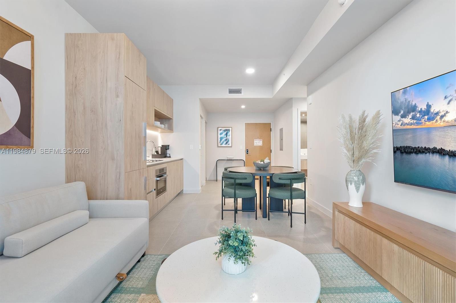 A modern studio apartment features a kitchenette, dining area, and living space with light wood — 11 NE 6th St # 1805, Miami FL 33132, MIAMI, FL
