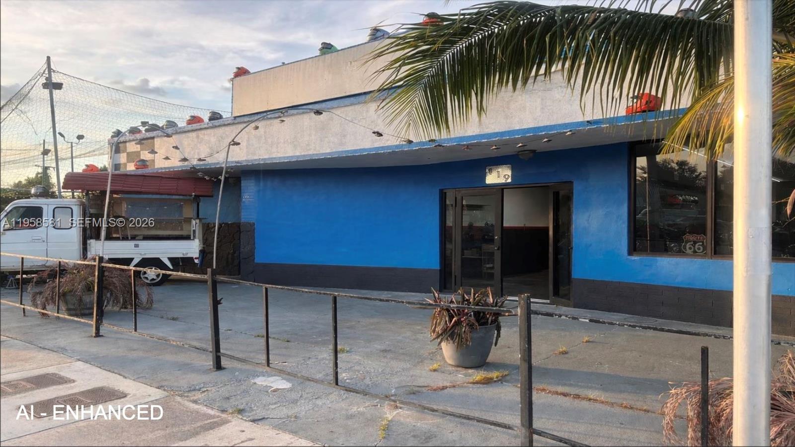 A blue commercial building exterior features a flat roof, glass entrance doors, and a parking area — 419 NW 79th St, Miami FL 33150, MIAMI, FL