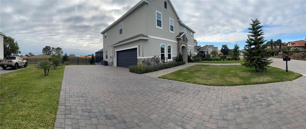 A two-story house with a paved driveway, a garage, and a landscaped front yard — 17708 SAWGRASS RUN, DEER ISLAND, FL