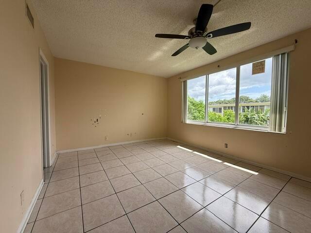 An empty living room features beige walls, a tiled floor, and a ceiling fan — 6005 Del Lago Circle # 305, Sunrise FL 33313, SUNRISE, FL