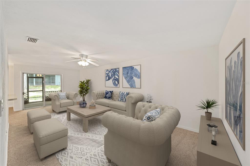 A living room features beige tufted furniture, a coffee table, and a sliding glass door — 501 SW 75TH STREET UNIT H6, GAINESVILLE, FL