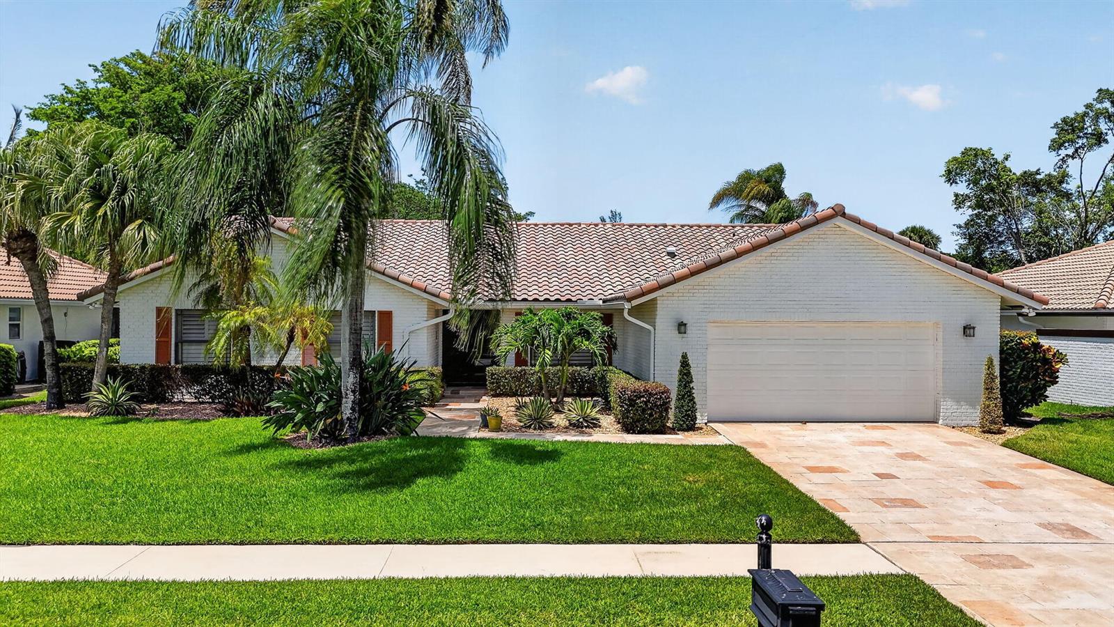 A single-story white brick house with a tiled roof, a two-car garage, and palm trees — 10221 Harbourtown Court, Boca Raton FL 33498, BOCA RATON, FL