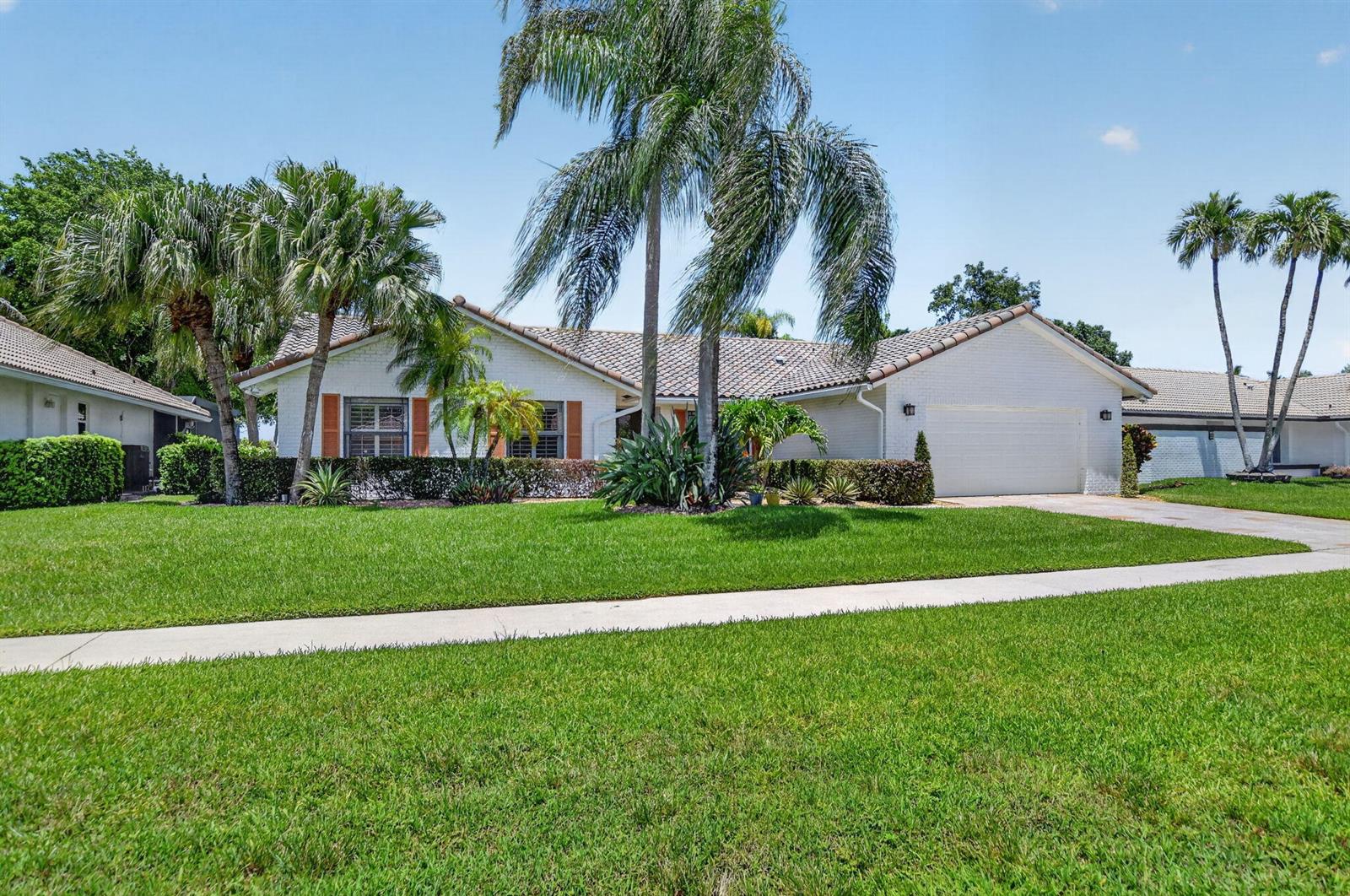A single-story white brick house with a tiled roof, palm trees, and a green lawn — 10221 Harbourtown Court, Boca Raton FL 33498, BOCA RATON, FL
