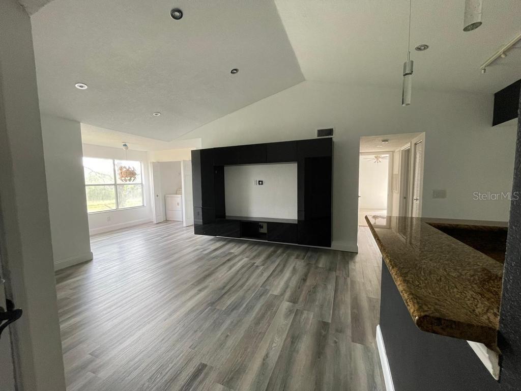 A living room features wood-look flooring, a large black media unit, and recessed lighting — 5140 CONROY ROAD UNIT 37, ORLANDO, FL
