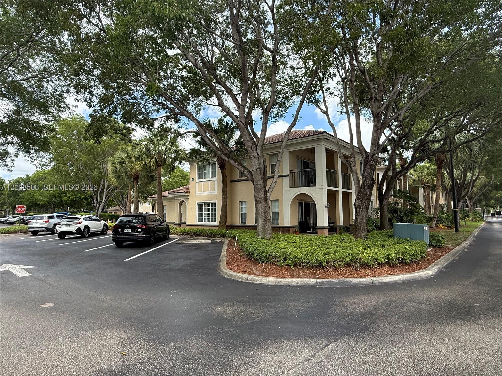 A two-story apartment building with a parking lot and mature trees in front — 2442 Centergate Dr # 206, Miramar FL 33025, MIRAMAR, FL