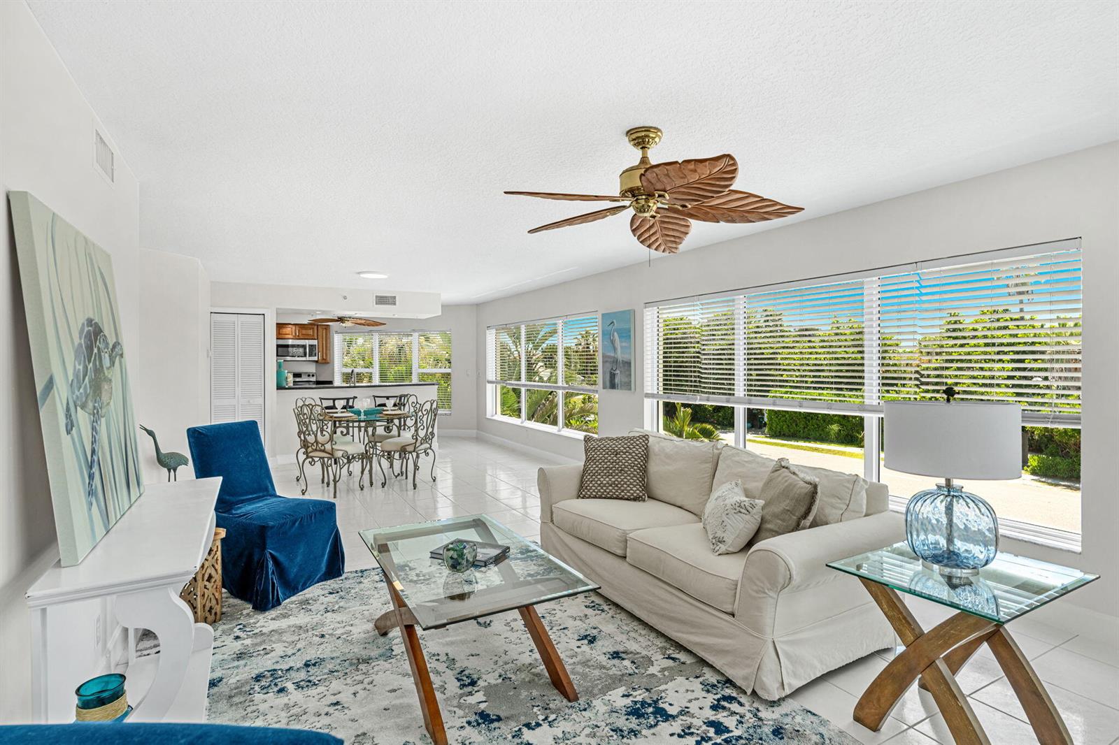 A bright living room with white walls, tile floors, a ceiling fan, and large windows — 1155 S Atlantic Avenue # 203, Cocoa Beach FL 32931, COCOA BEACH, FL