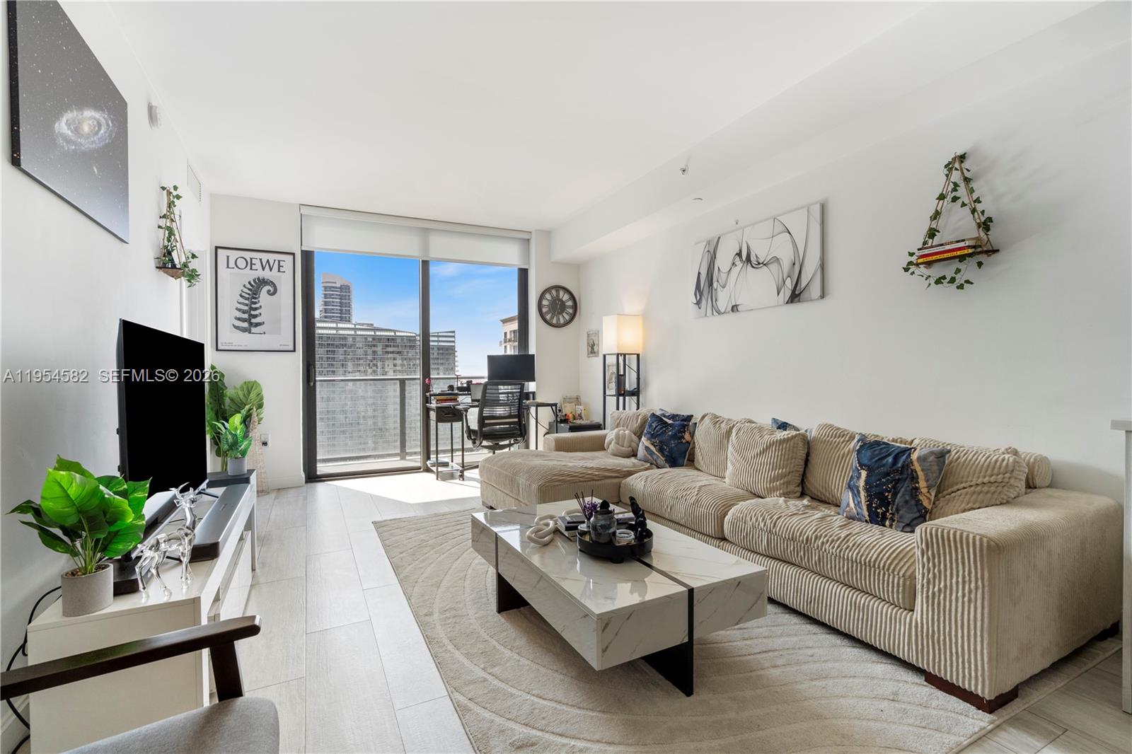 A modern living room features a beige sectional sofa, marble coffee table, and balcony view — 55 SW 9th St # 3005, Miami FL 33130, MIAMI, FL