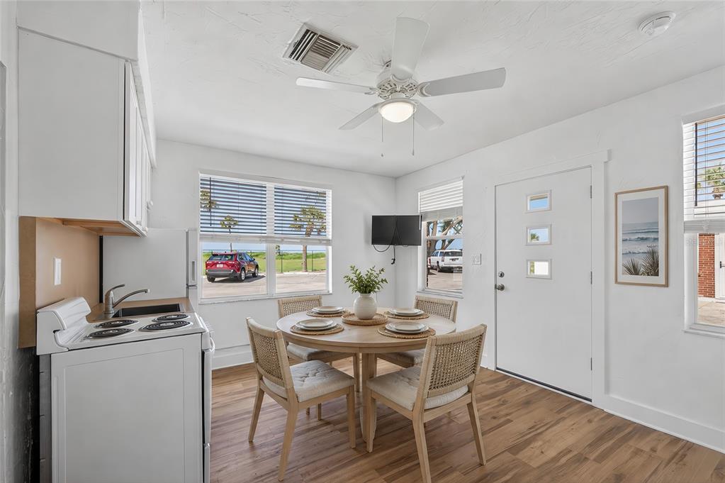A small dining area features a round wooden table, four chairs, and a kitchen corner — 908 VILLAS DRIVE UNIT 31, VENICE, FL