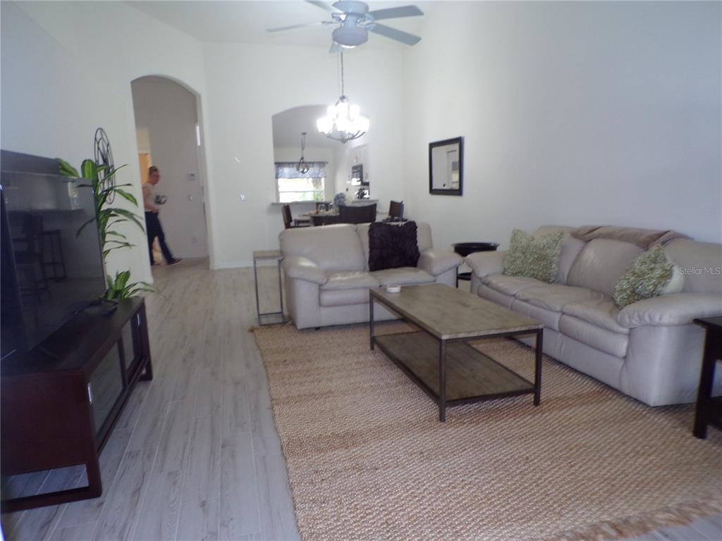 A living room features light-colored tile floors, a beige area rug, and two leather sofas — 3845 ALBACETE CIRCLE UNIT 50, PUNTA GORDA, FL