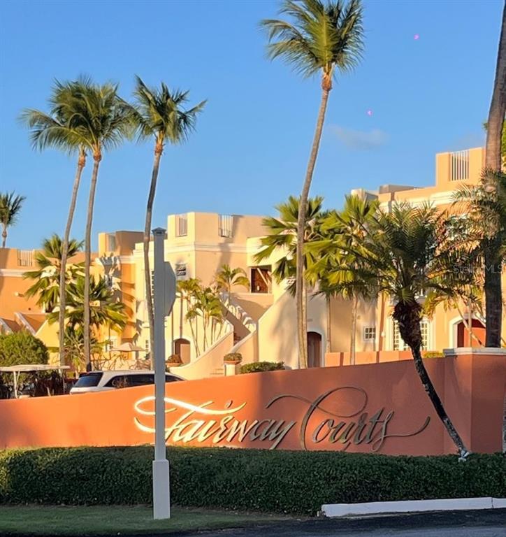 A tan multi-story building with palm trees behind a sign reading Fairway Courts — 806 S FAIRWAY COURTS UNIT 806, PALMAS DEL MAR, HUMACAO, PR