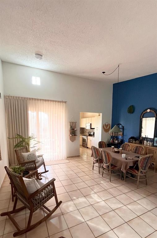 A dining area and living space feature tile floors, a blue accent wall, and rocking chairs — 806 S FAIRWAY COURTS UNIT 806, PALMAS DEL MAR, HUMACAO, PR