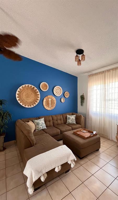 A living room features a blue accent wall with woven decor above a brown sectional — 806 S FAIRWAY COURTS UNIT 806, PALMAS DEL MAR, HUMACAO, PR