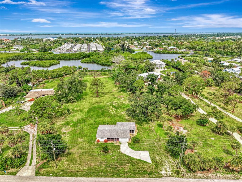 An aerial view shows a single-story house on a large, grassy lot with surrounding trees — 780 S OXFORD DRIVE, ENGLEWOOD, FL