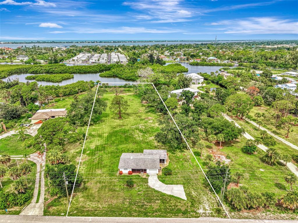 An aerial view shows a single-story house situated on a large, grassy, tree-lined lot — 780 S OXFORD DRIVE, ENGLEWOOD, FL