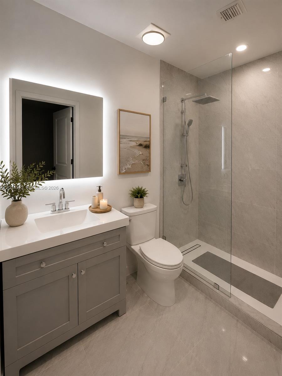 A modern bathroom features a gray vanity, a walk-in glass shower, and a backlit mirror — 652 NE 63rd St # 105, Miami FL 33138, MIAMI, FL