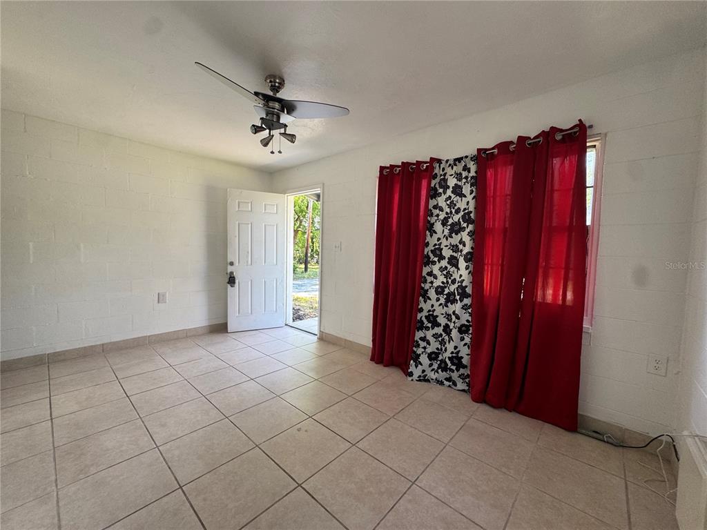 A room with white block walls, tiled floors, a ceiling fan, and red curtains — 1715 1/2 MARTIN LUTHER KING JR BOULEVARD, BARTOW, FL