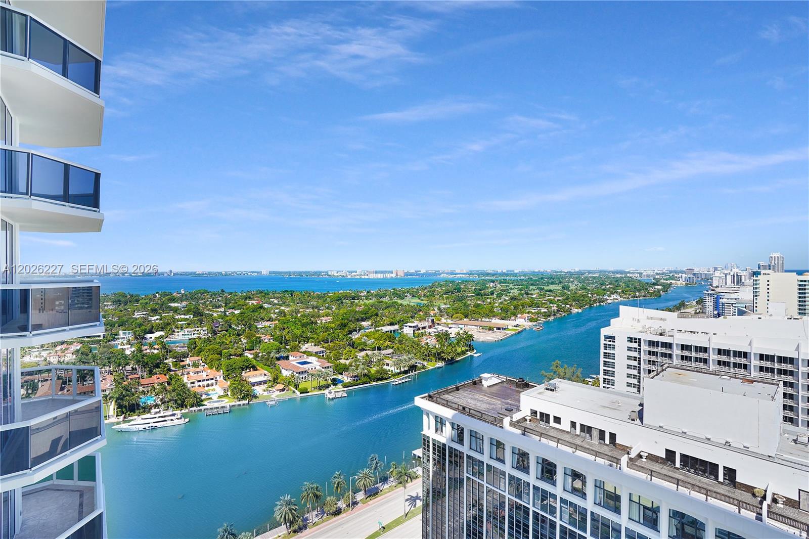 An elevated view shows a coastal waterway surrounded by residential buildings and lush green trees — 4779 Collins Ave # 2908, Miami Beach FL 33140, MIAMI BEACH, FL