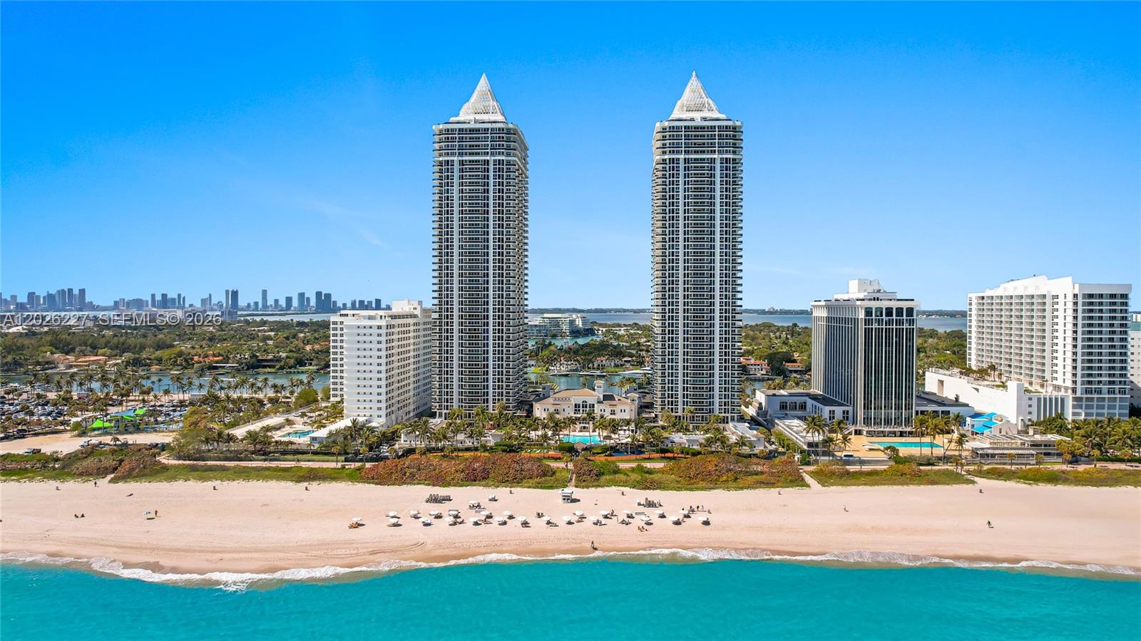 An aerial view shows two tall, pointed-roof residential towers situated along a sandy beach — 4779 Collins Ave # 2908, Miami Beach FL 33140, MIAMI BEACH, FL