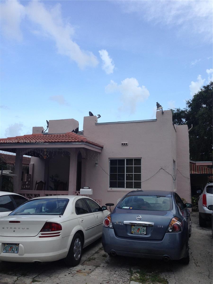 A pink single-story house with a tiled porch roof and two cars parked in front — 3674 SW 25th St, Miami FL 33133, MIAMI, FL