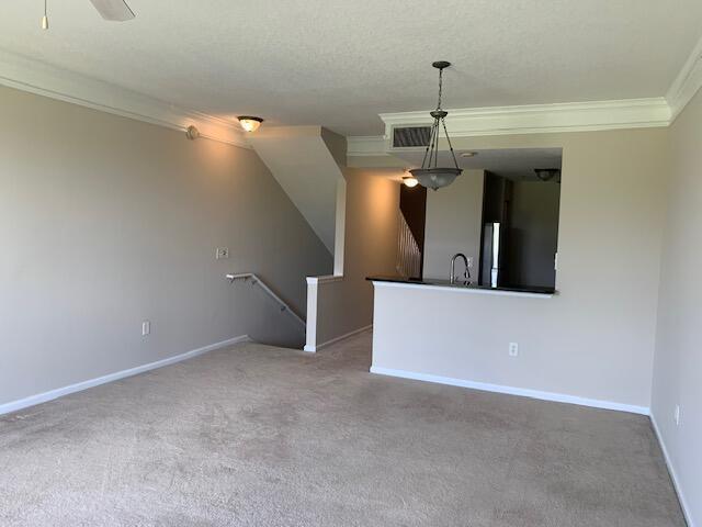 An interior view shows a carpeted living area with a staircase and a kitchen breakfast bar — 2058 Alta Meadows Lane # 2503, Delray Beach FL 33444, DELRAY BEACH, FL