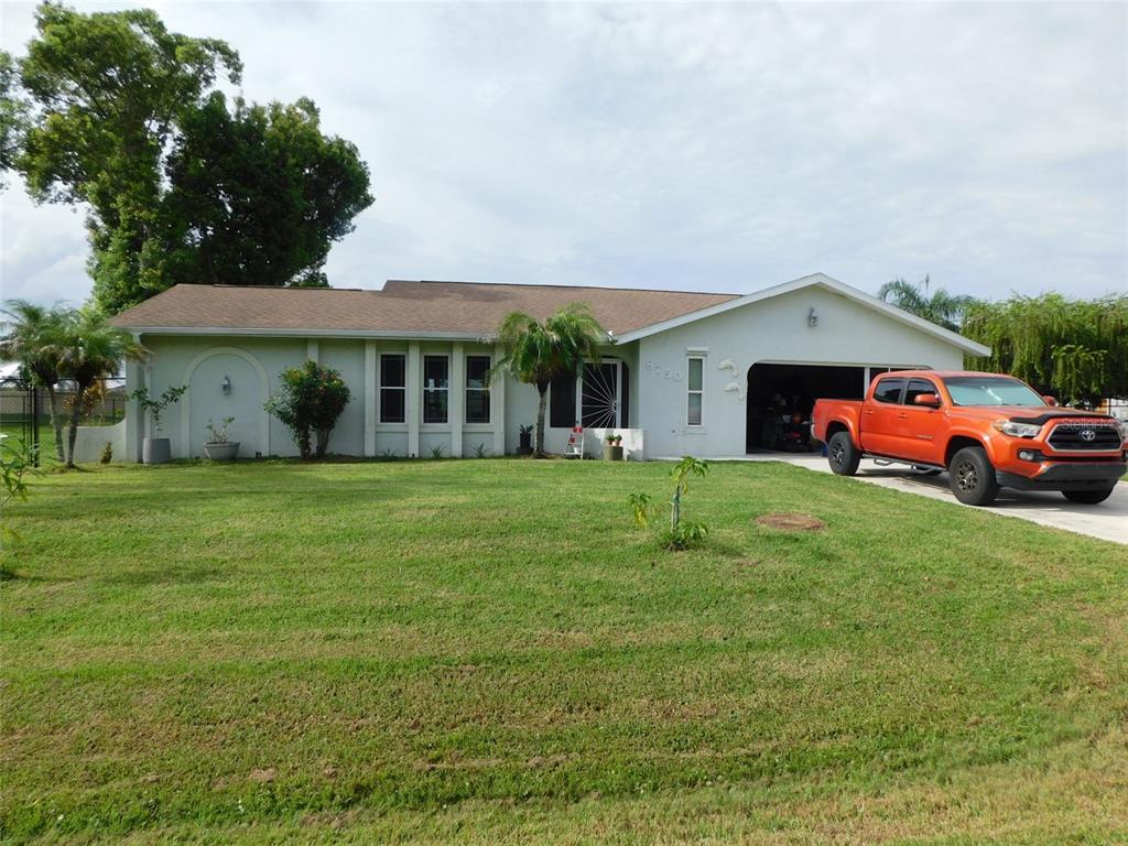 A single-story house with a light-colored exterior, a brown roof, and an orange pickup truck — 8750 SW LIVERPOOL ROAD, ARCADIA, FL