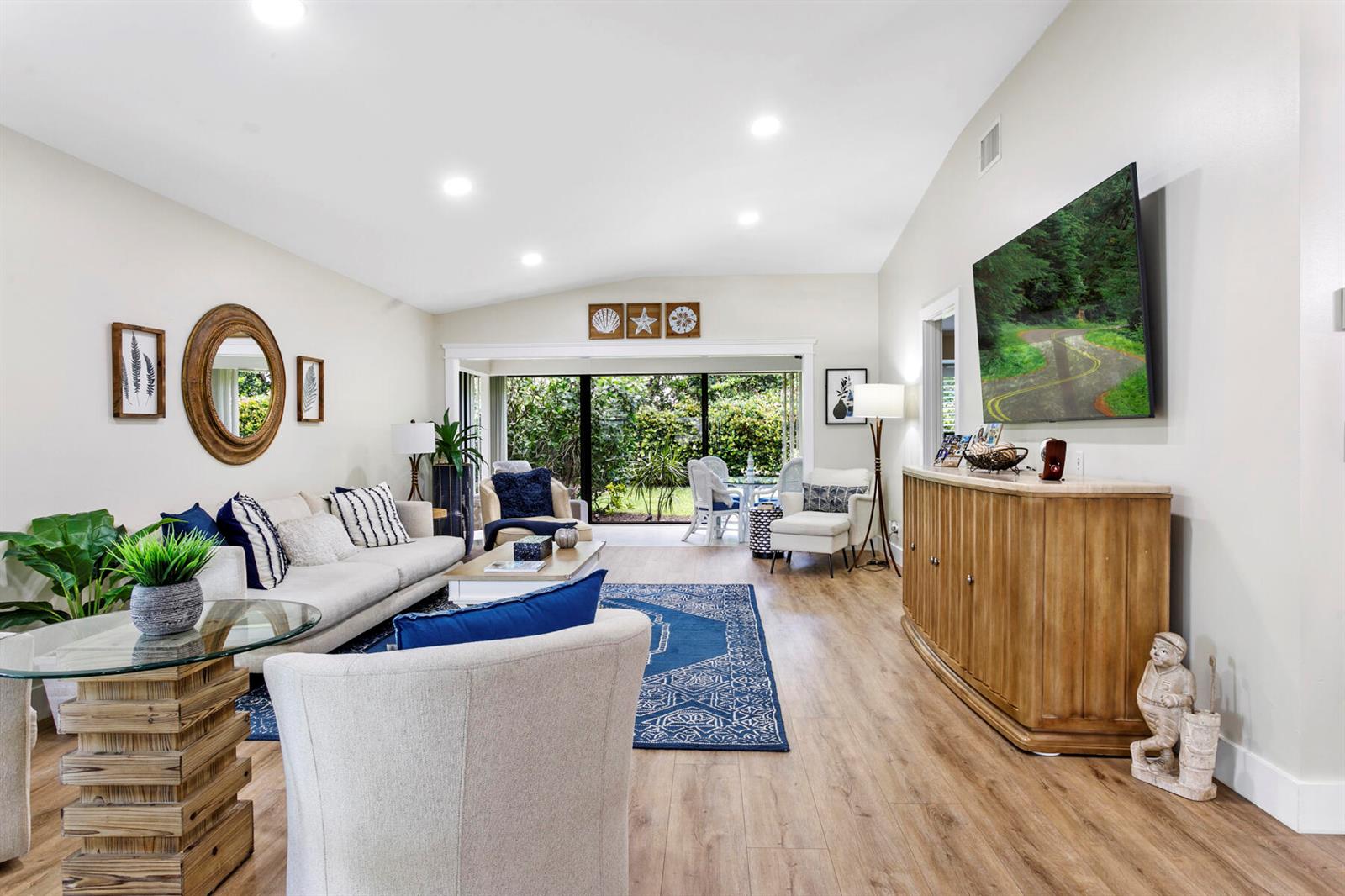 A living room features a beige sofa, blue area rug, wooden console, and glass-topped table — 3616 Freshwater Drive, Jupiter FL 33477, JUPITER, FL