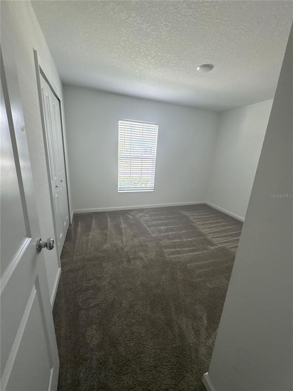 An empty bedroom features gray carpeting, white walls, and a window with closed blinds — 4269 NIGHT CAPS WAY, KISSIMMEE, FL