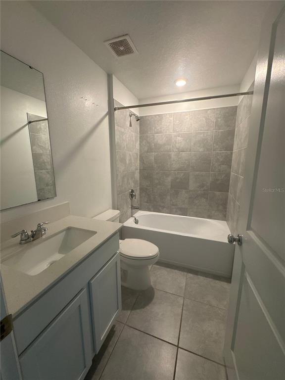 A bathroom features a vanity with a sink, a toilet, and a tiled shower-tub combination — 4269 NIGHT CAPS WAY, KISSIMMEE, FL