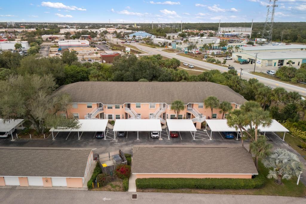 An aerial view shows a multi-story apartment building with covered parking and detached garages — 19310 WATER OAK DRIVE UNIT 103, PORT CHARLOTTE, FL