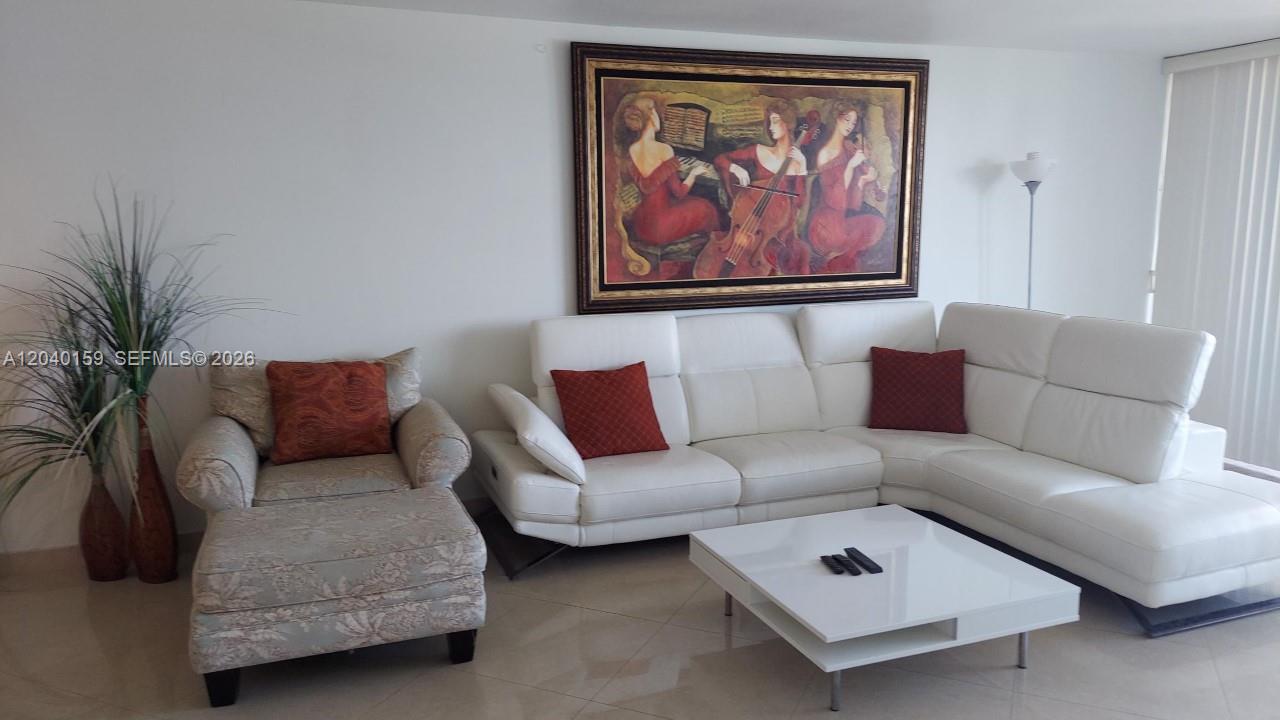 A living room features a white sectional sofa, a patterned armchair, and a large framed painting — 3140 S Ocean Dr # 1510, Hallandale Beach FL 33009, HALLANDALE BEACH, FL
