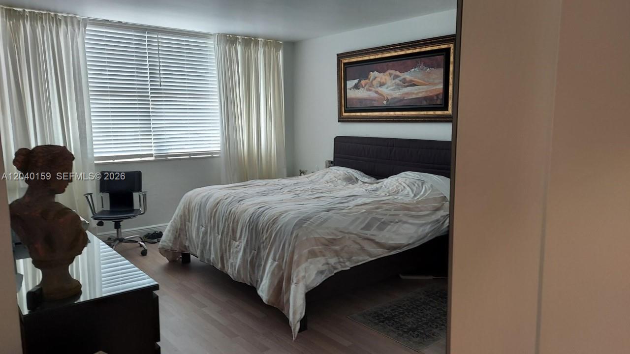 A bedroom features a bed with a dark headboard, a painting, and a bust statue — 3140 S Ocean Dr # 1510, Hallandale Beach FL 33009, HALLANDALE BEACH, FL