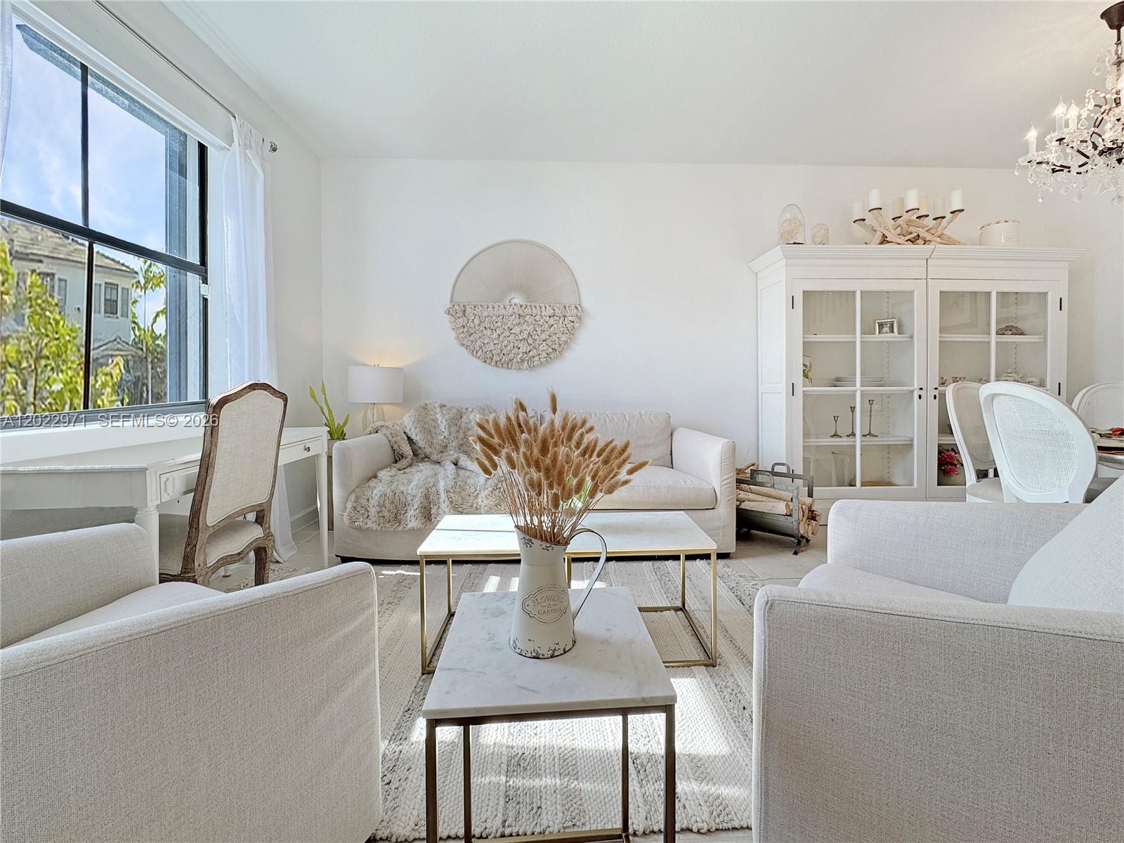 A bright living room features white furniture, a marble coffee table, and a large window — 14813 SW 183rd Ter # 14813, Miami FL 33187, MIAMI, FL