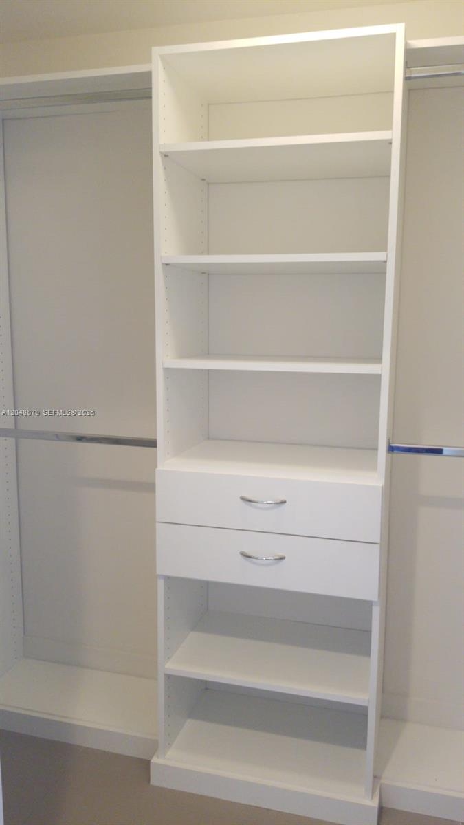 A white closet organizer with shelves and two drawers stands between two hanging rods — 999 SW 1st Ave # 3308, Miami FL 33130, MIAMI, FL