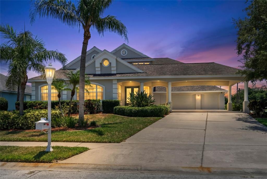 An aerial view shows a two-story house with a shingled roof and a concrete driveway — 4306 BARRACUDA DRIVE, BRADENTON, FL