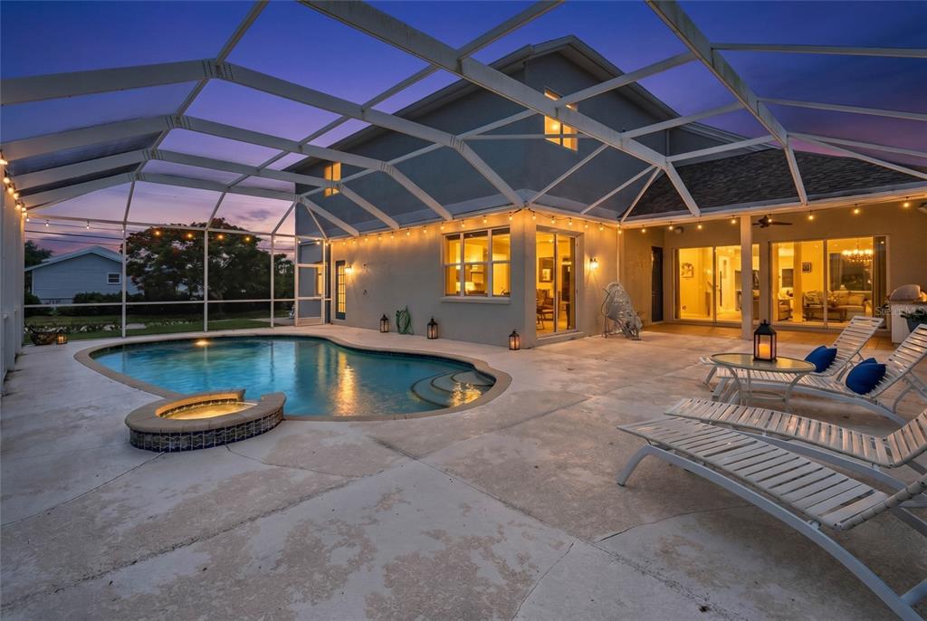 A single-story house with a carport, palm trees, and a concrete driveway at sunset — 4306 BARRACUDA DRIVE, BRADENTON, FL