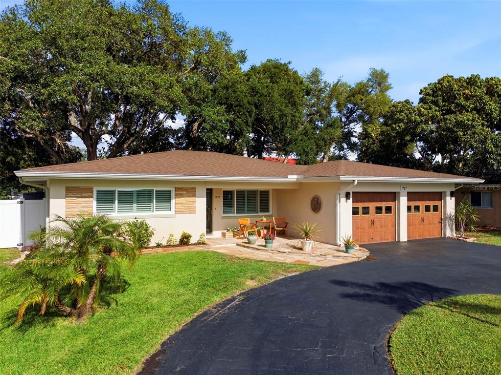 A single-story house with a two-car garage and a stone walkway at dusk — 1727 CYPRESS AVENUE, BELLEAIR, FL