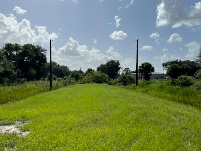 A grassy, open lot features two utility poles with power lines stretching across the sky — 15134 NW 306th Street, Okeechobee FL 34972, OKEECHOBEE, FL