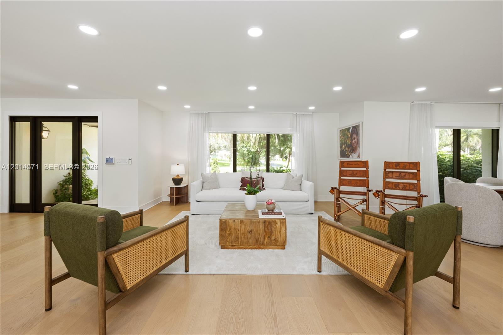 A bright living room features a white sofa, two green armchairs, and a wooden coffee table — 15110 N Saxon Cir, Southwest Ranches FL 33331, SOUTHWEST RANCHES, FL