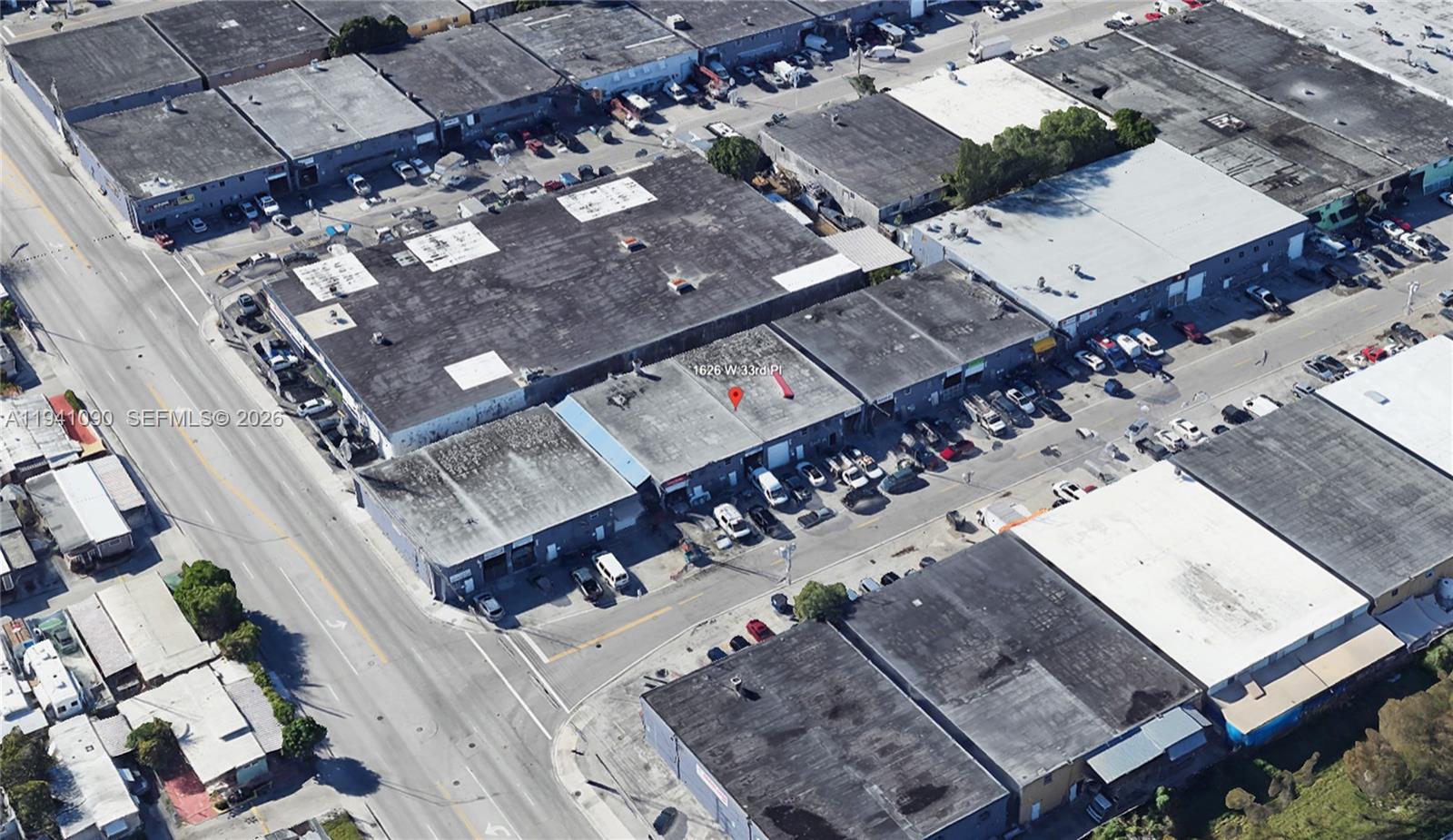 An aerial view shows a commercial warehouse complex with flat roofs and parking areas — 1626 W 33rd Pl, Hialeah FL 33012, HIALEAH, FL