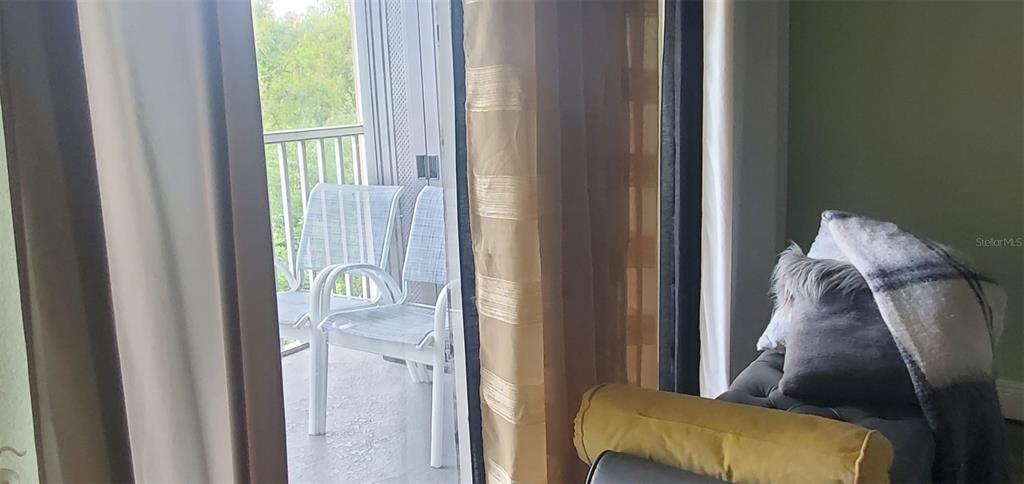 A view from inside a room looking out through a sliding door to a balcony — 9517 AMBERDALE COURT UNIT 202, RIVERVIEW, FL