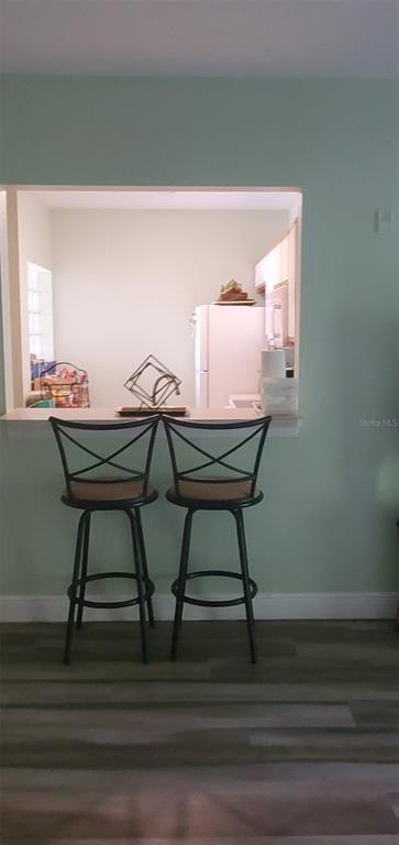 Two black bar stools sit at a kitchen pass-through window against a light green wall — 9517 AMBERDALE COURT UNIT 202, RIVERVIEW, FL