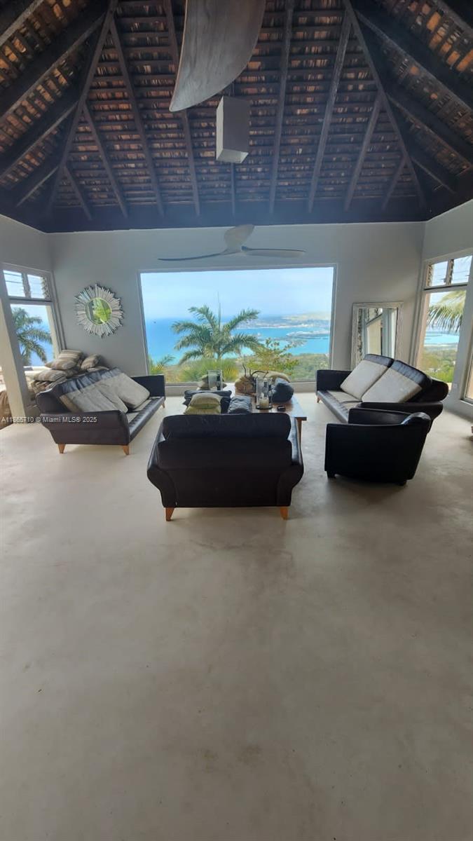 A living room with dark leather furniture, a vaulted ceiling, and a large ocean-view window — 00 Villa,Montego Bay, Jamaica, NA, NA
