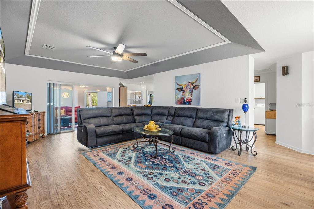 A kitchen features white cabinets, a black tile backsplash, stainless steel appliances, and wood flooring — 297 FLAMINGO BOULEVARD, PORT CHARLOTTE, FL
