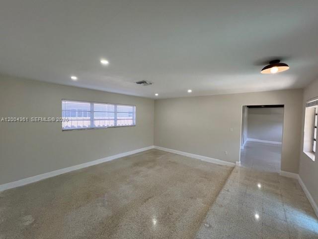 A spacious, empty room features light-colored walls, recessed lighting, and polished terrazzo flooring — 2500 SW 58th Ave, Miami FL 33155, MIAMI, FL