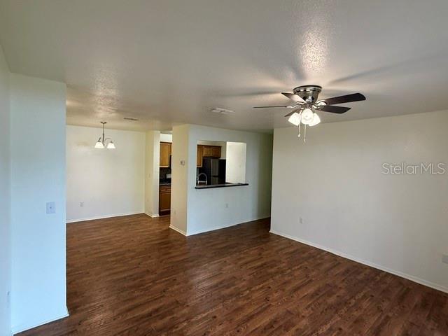 An open-concept living area features wood-look flooring, a ceiling fan, and a kitchen pass-through window — 3705 SW 27TH STREET UNIT 916, GAINESVILLE, FL