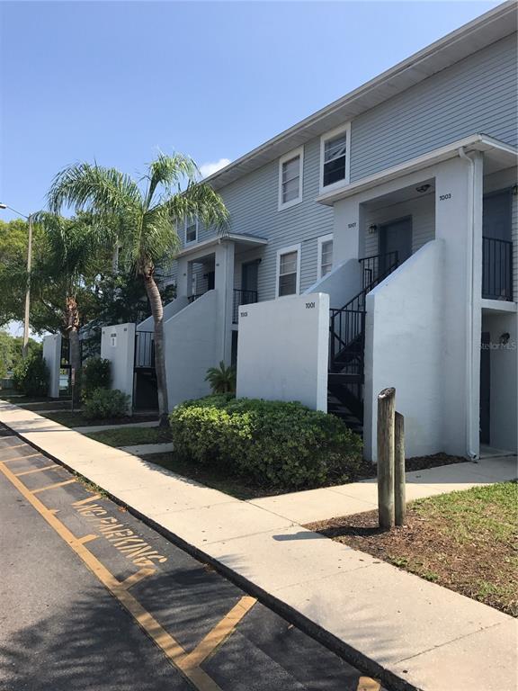 An exterior view of a multi-story apartment building with stairs and a sidewalk — 7101 E BANK DRIVE UNIT 7101, TAMPA, FL