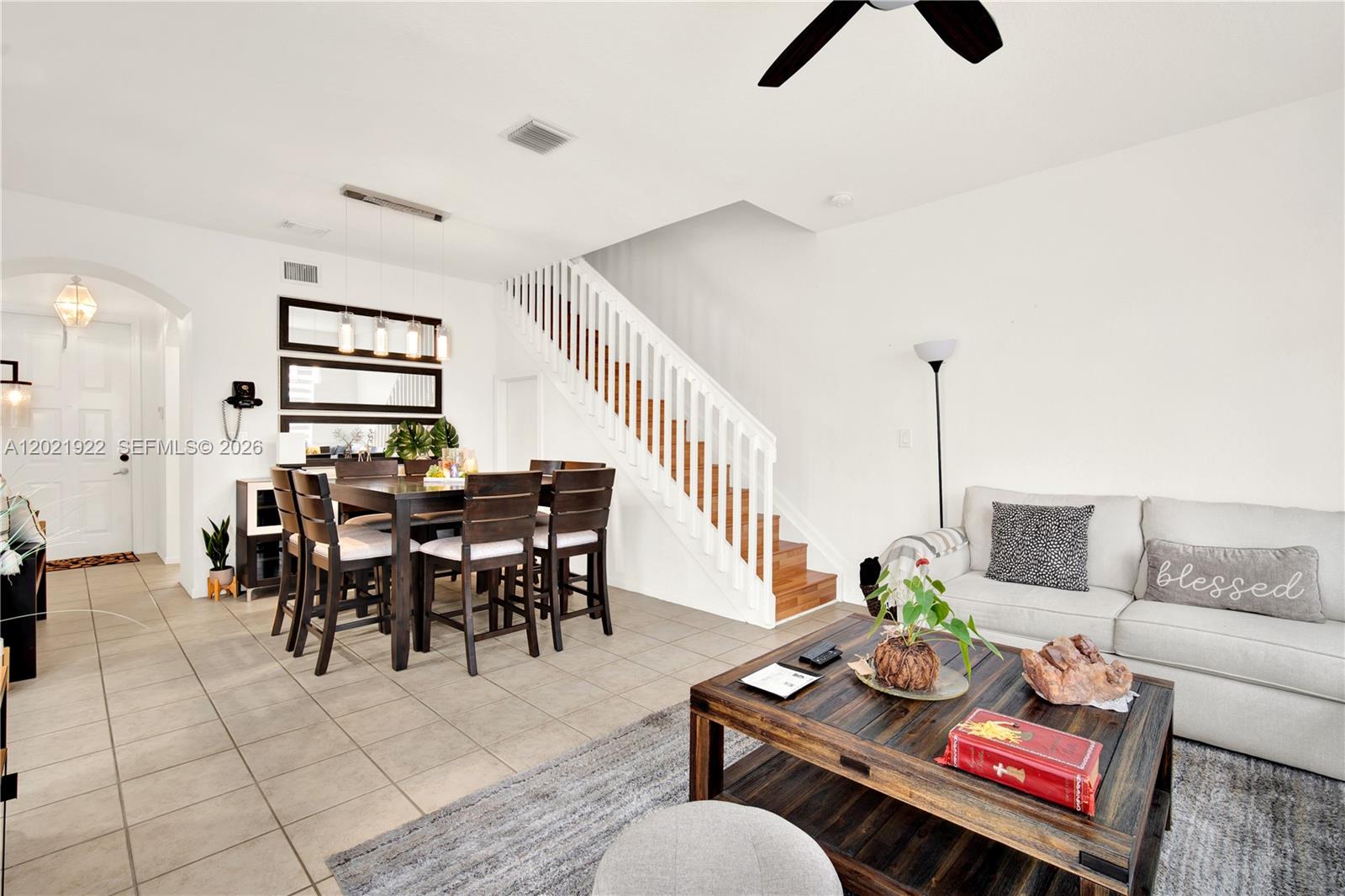 A living and dining area features a staircase, tile flooring, and a wooden coffee table — 18730 SW 25th Ct, Miramar FL 33029, MIRAMAR, FL