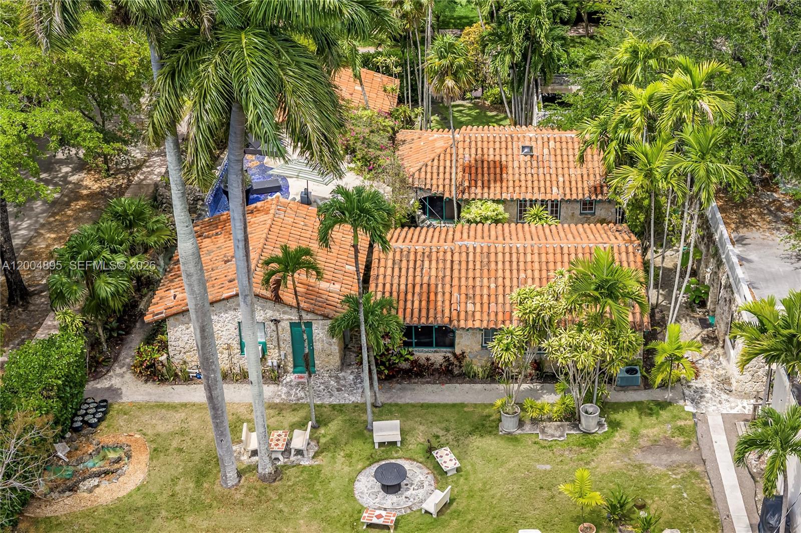 An aerial view shows a stone house with a terracotta roof and a backyard — 1301 Milan Ave, Coral Gables FL 33134, CORAL GABLES, FL
