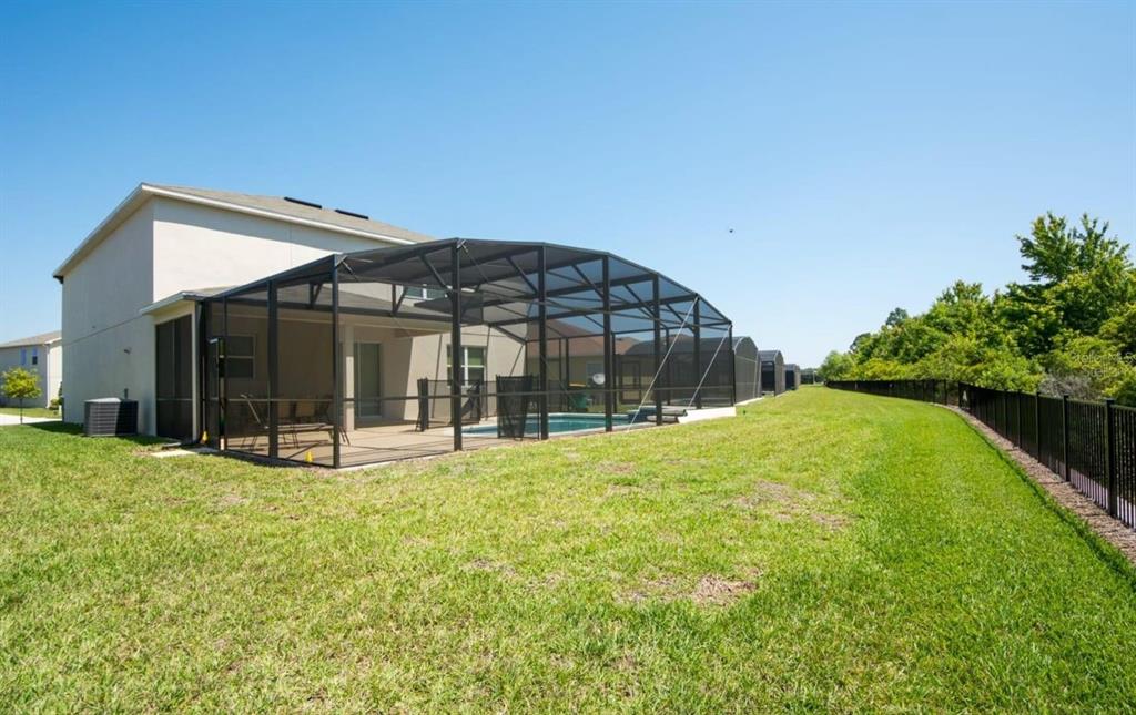 A two-story house features a screened-in pool enclosure and a fenced backyard — 4748 BLUE DIAMOND STREET, KISSIMMEE, FL